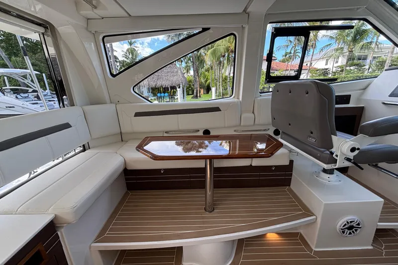  Yacht Photos Pics 2024 Pursuit OS 445 Offshore interior with elegant seating and wooden table.