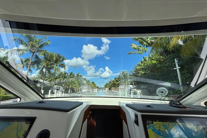  Yacht Photos Pics 2024 Pursuit OS 445 Offshore boat interior view with tropical palm trees and blue sky.
