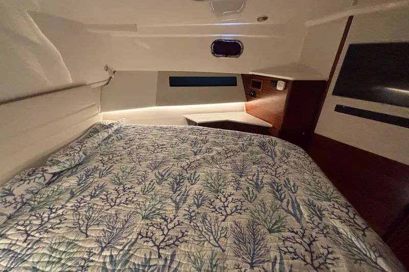  Yacht Photos Pics 2024 Pursuit OS 445 Offshore cabin with a cozy bed and elegant interior design.