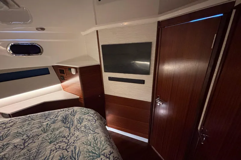  Yacht Photos Pics 2024 Pursuit OS 445 Offshore cabin interior with wood paneling and modern amenities.