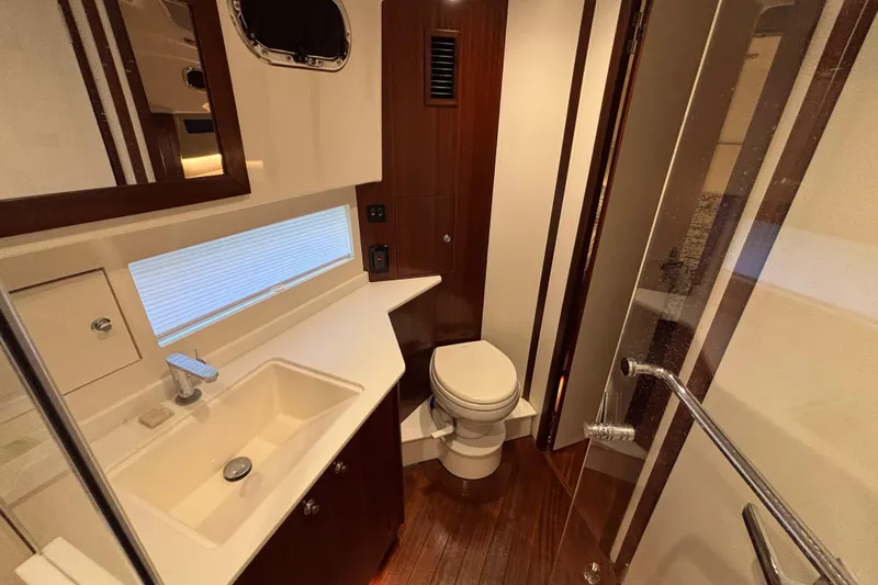  Yacht Photos Pics Luxurious bathroom in 2024 Pursuit OS 445 Offshore yacht with modern fixtures and wood accents.