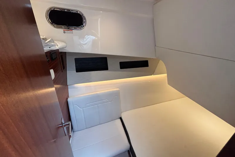  Yacht Photos Pics 2024 Pursuit OS 445 Offshore cabin interior with modern seating and ambient lighting.