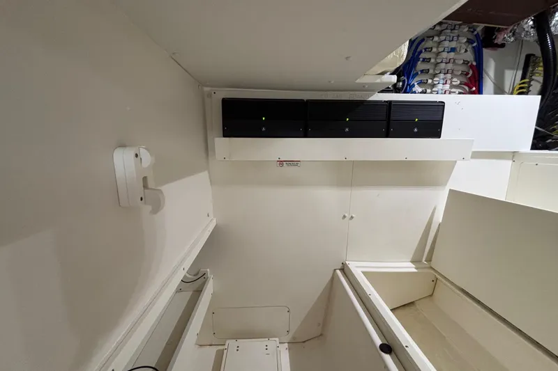  Yacht Photos Pics 2024 Pursuit OS 445 Offshore interior with electrical panel and storage compartments.