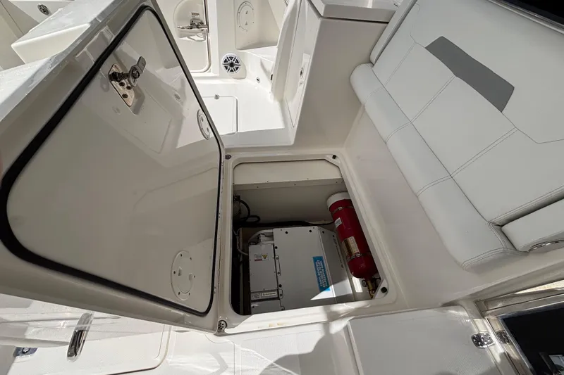  Yacht Photos Pics 2024 Pursuit OS 445 Offshore boat storage compartment with fire extinguisher and equipment.