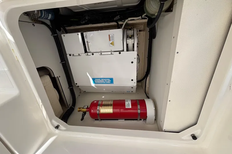  Yacht Photos Pics 2024 Pursuit OS 445 Offshore engine compartment with fire extinguisher and mechanical components.
