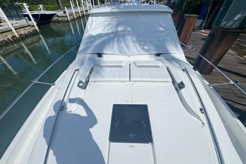  Yacht Photos Pics 2024 Pursuit OS 445 Offshore boat deck with white cover, docked in a marina.