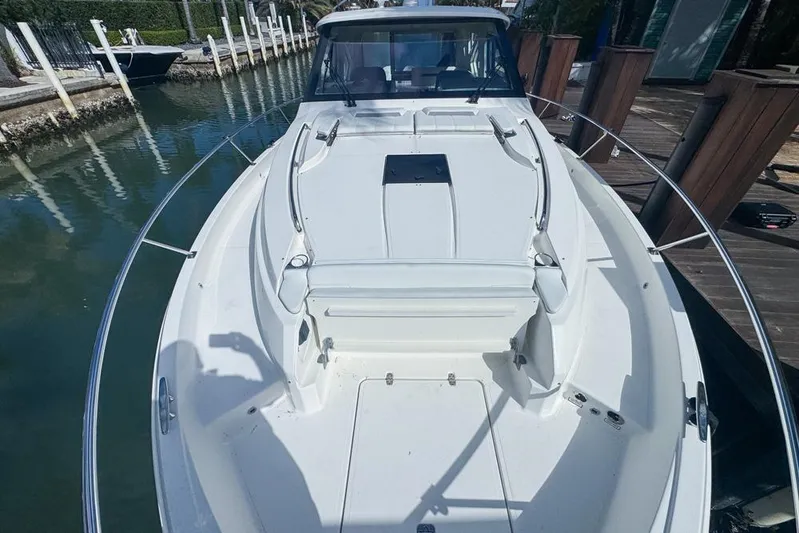  Yacht Photos Pics 2024 Pursuit OS 445 Offshore boat docked, showcasing spacious deck and sleek design.