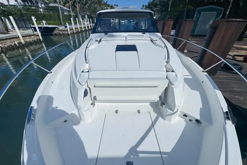  Yacht Photos Pics 2024 Pursuit OS 445 Offshore boat docked, showcasing spacious deck and sleek design.