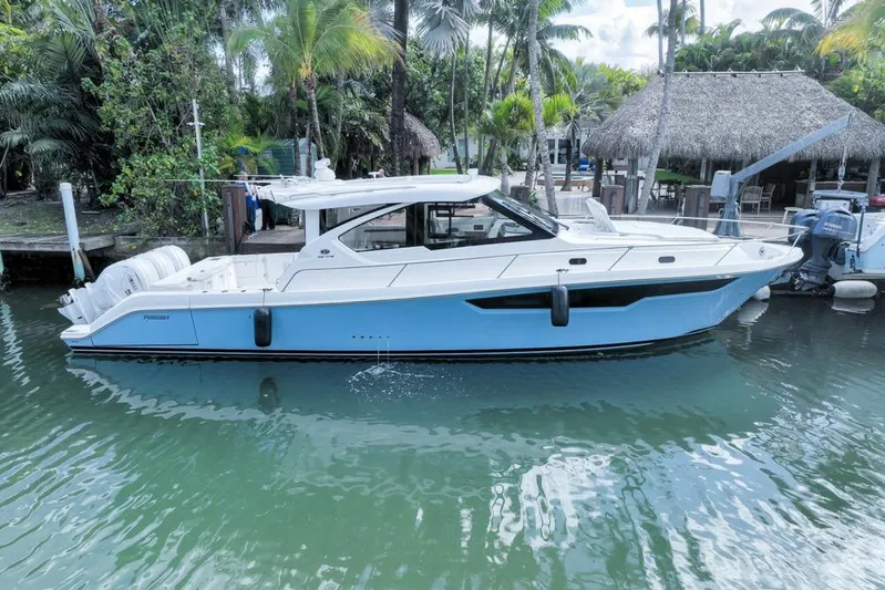  Yacht Photos Pics 2024 Pursuit OS 445 Offshore boat docked in tropical marina setting.