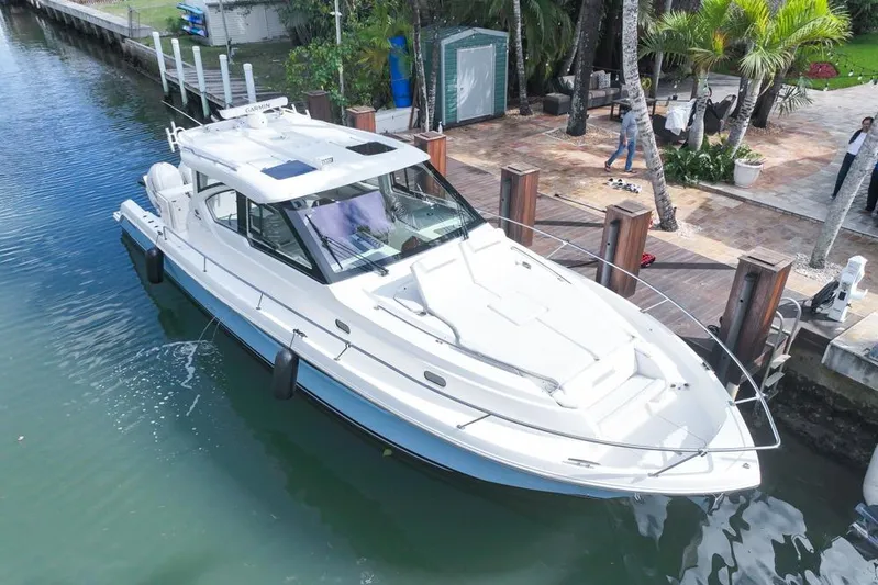  Yacht Photos Pics 2024 Pursuit OS 445 Offshore boat docked in a scenic waterfront setting.