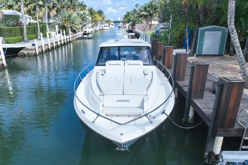  Yacht Photos Pics 2024 Pursuit OS 445 Offshore yacht docked in a scenic canal setting.