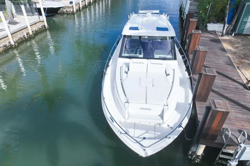  Yacht Photos Pics 2024 Pursuit OS 445 Offshore boat docked in a serene canal setting.