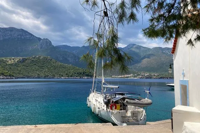  Yacht Photos Pics Beneteau Oceanis Clipper 473 yacht docked by scenic mountainous coastline, 2006 model.