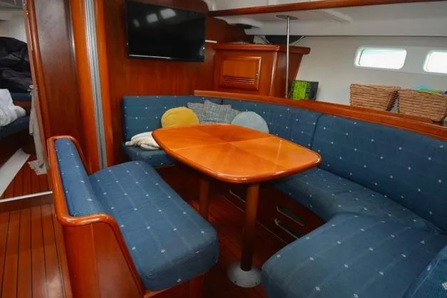  Yacht Photos Pics Interior of 2006 Beneteau Oceanis Clipper 473 with blue seating and wooden table.