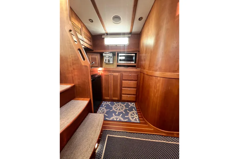 Island Time Yacht Photos Pics 2006 Sabre 38 Hard Top Express interior with wooden cabinetry and nautical-themed rug.