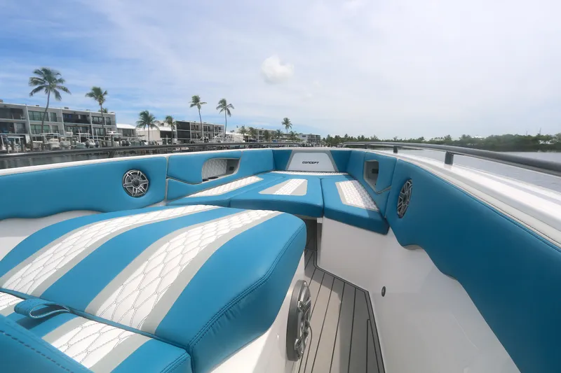  Yacht Photos Pics 2025 Concept 30 Open Deck boat with blue and white seating, docked near waterfront homes.