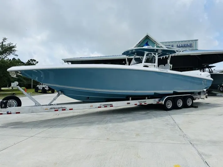  Yacht Photos Pics 2020 Fountain 38cc boat on a trailer in front of a marine dealership.