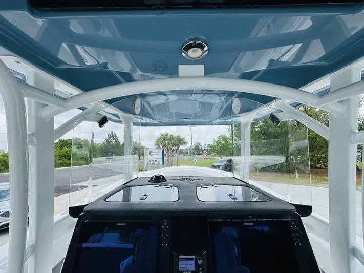  Yacht Photos Pics 2020 Fountain 38cc boat cockpit with modern navigation system and blue hardtop.