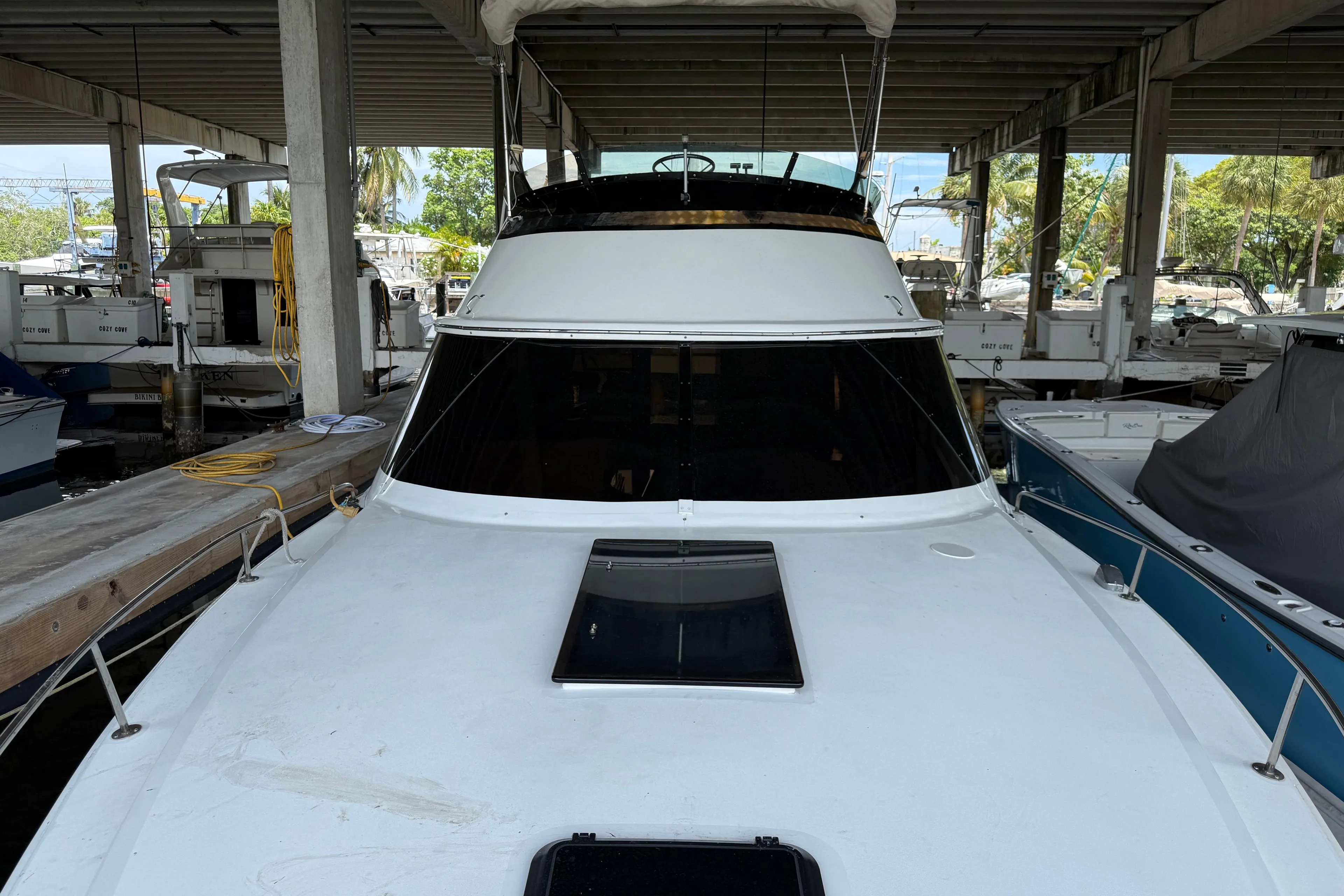 1984 Custom 38 yacht docked in a covered marina, front view.