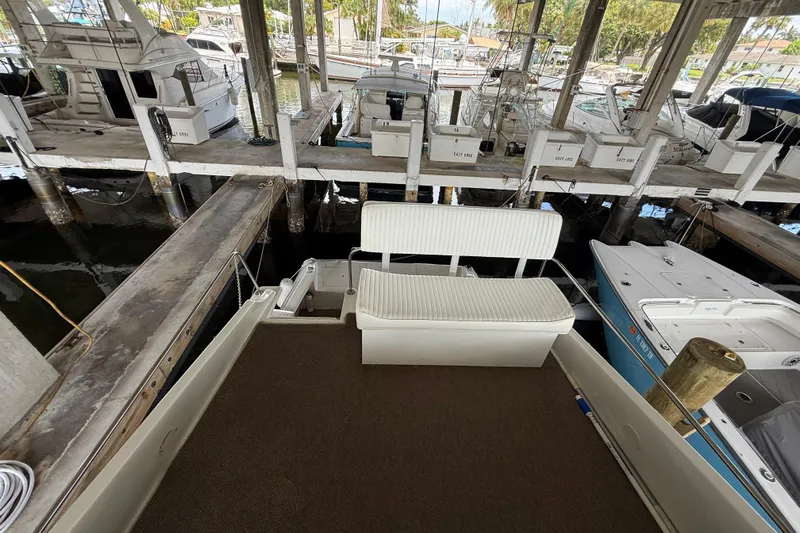 Caribbean Express Yacht Photos Pics 1984 Custom 38 boat docked in a marina with seating area and surrounding vessels.