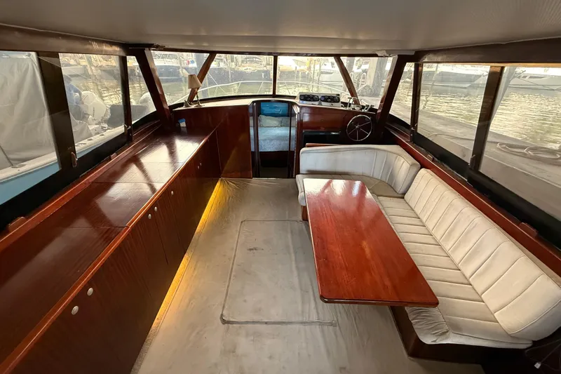 Caribbean Express Yacht Photos Pics Interior of 1984 Custom 38 yacht with wooden table and white seating.