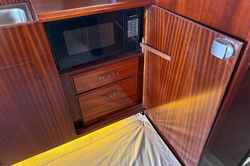 Caribbean Express Yacht Photos Pics Wooden cabinetry with microwave and drawers in 1984 Custom 38 boat interior.