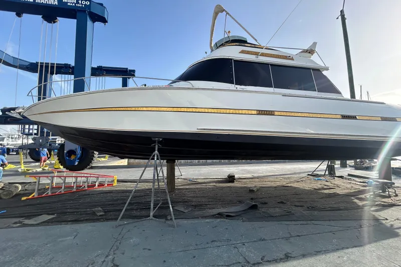 Caribbean Express Yacht Photos Pics 1984 Custom 38 boat on dry dock, marina background, clear sky.