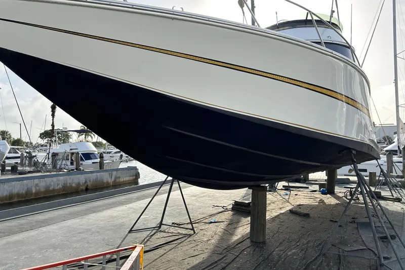 Caribbean Express Yacht Photos Pics 1984 Custom 38 boat on dry dock, marina background, clear sky.