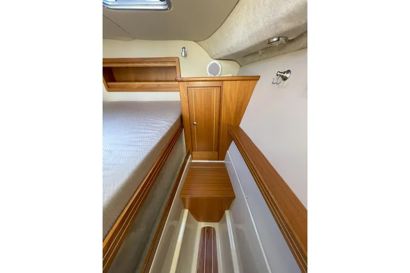Sweet Jane Yacht Photos Pics 2015 Aspen C100 cabin interior with wooden cabinetry and bed.