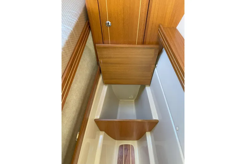 Sweet Jane Yacht Photos Pics 2015 Aspen C100 interior storage compartment with wooden finish and open hatch.