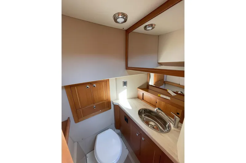 Sweet Jane Yacht Photos Pics Compact bathroom in 2015 Aspen C100 boat with wooden cabinetry and modern fixtures.