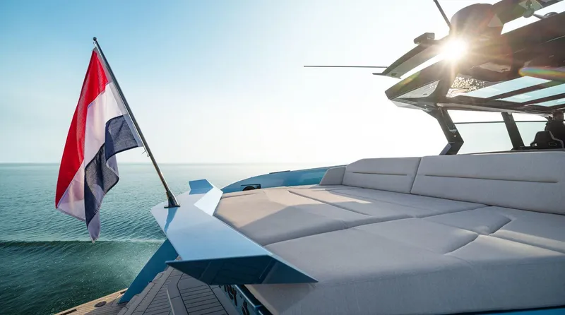 Chapter 3 Yacht Photos Pics 2024 Vanquish Yachts VQ70 with sun deck and flag, cruising on open water.