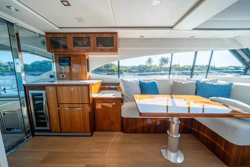 Water Dog Yacht Photos Pics Luxurious interior of 2024 Riviera 5400 Sport Yacht with elegant wood finishes and scenic views.