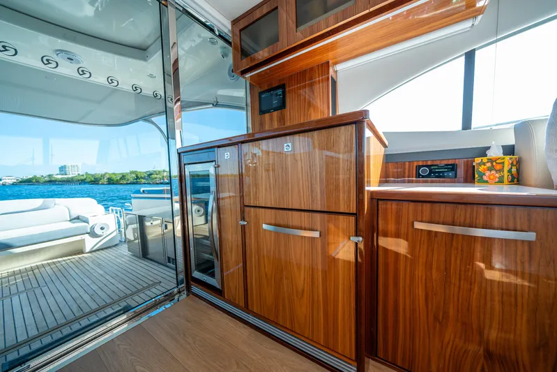 Water Dog Yacht Photos Pics Luxurious interior of 2024 Riviera 5400 Sport Yacht with wooden cabinetry and scenic water view.
