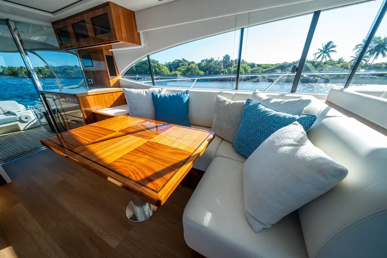 Water Dog Yacht Photos Pics Luxurious interior of 2024 Riviera 5400 Sport Yacht with elegant seating and wooden table.