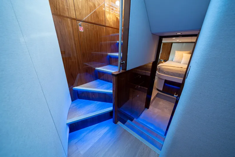 Water Dog Yacht Photos Pics Luxurious interior of 2024 Riviera 5400 Sport Yacht with illuminated stairs and cozy bedroom.