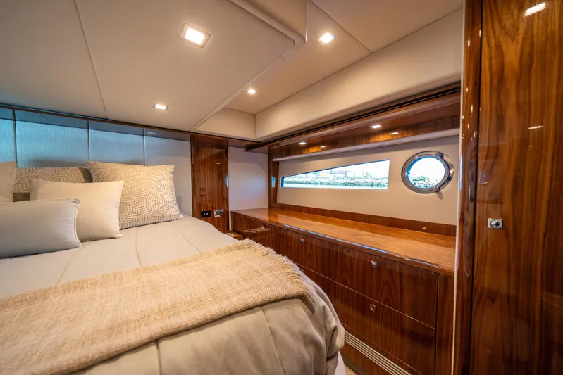 Water Dog Yacht Photos Pics Luxurious interior of 2024 Riviera 5400 Sport Yacht bedroom with elegant wood finish.