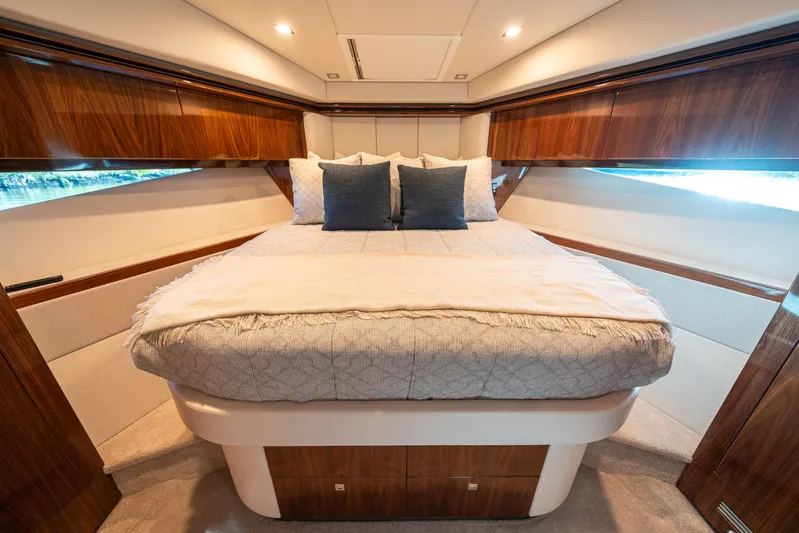 Water Dog Yacht Photos Pics Luxurious bedroom interior of 2024 Riviera 5400 Sport Yacht with elegant wood finishes.