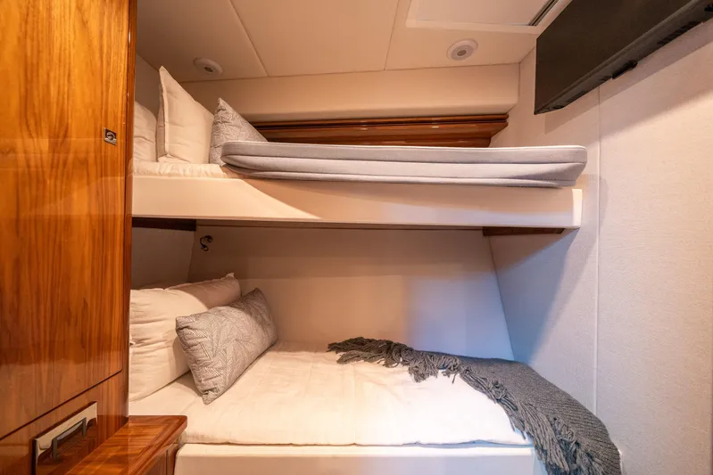 Water Dog Yacht Photos Pics 2024 Riviera 5400 Sport Yacht cabin with cozy bunk beds and elegant wood finish.