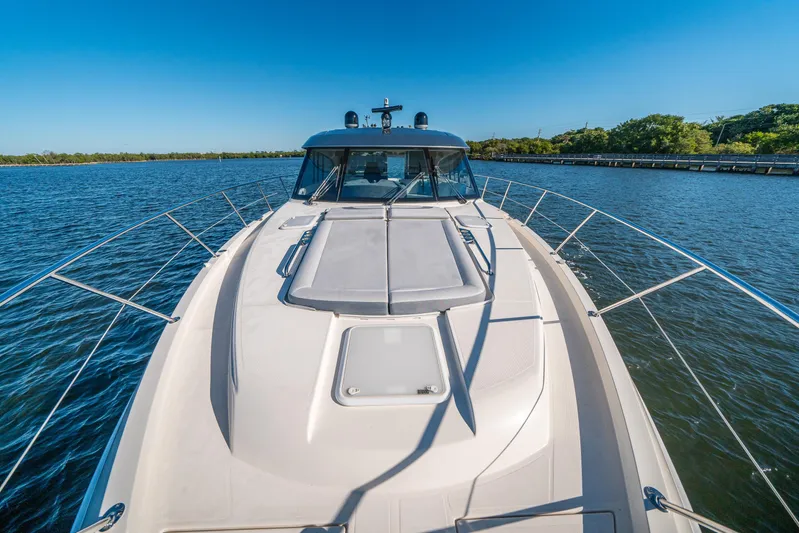 Water Dog Yacht Photos Pics 2024 Riviera 5400 Sport Yacht cruising on a sunny day, showcasing sleek design and luxury.