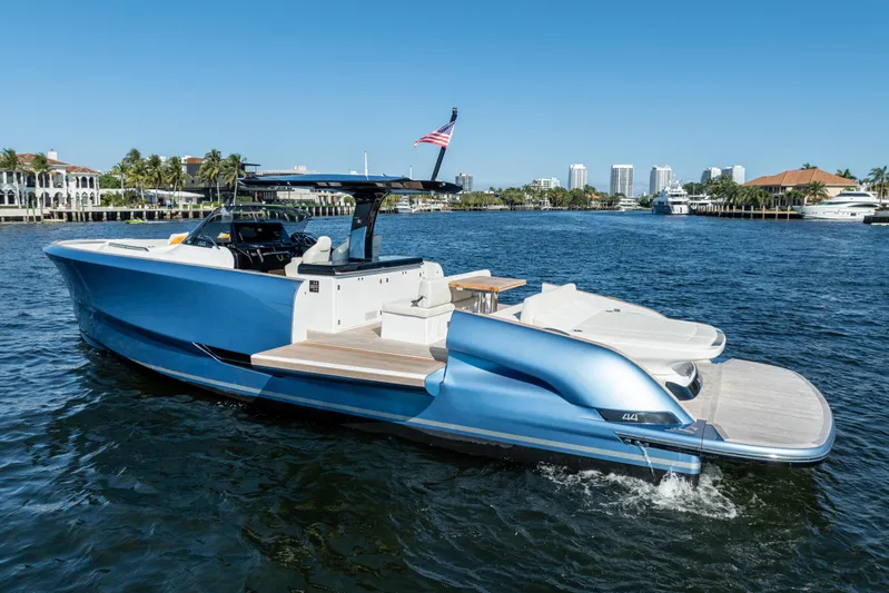  Yacht Photos Pics 2025 Solaris Power 44 Open yacht cruising on a sunny waterfront with city skyline.