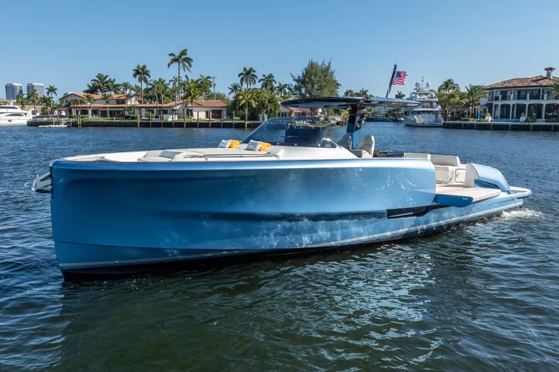  Yacht Photos Pics 2025 Solaris Power 44 Open yacht cruising on a sunny waterfront with palm trees.