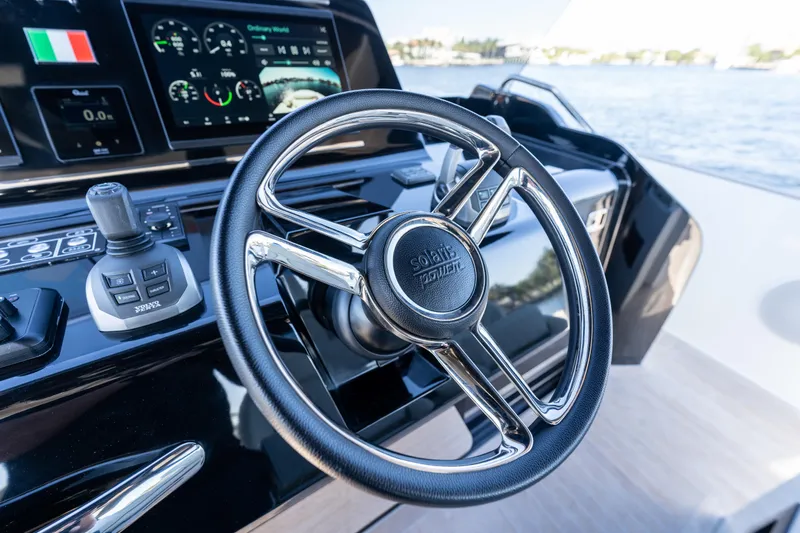  Yacht Photos Pics Steering wheel of 2025 Solaris Power 44 Open yacht with control panel and water view.