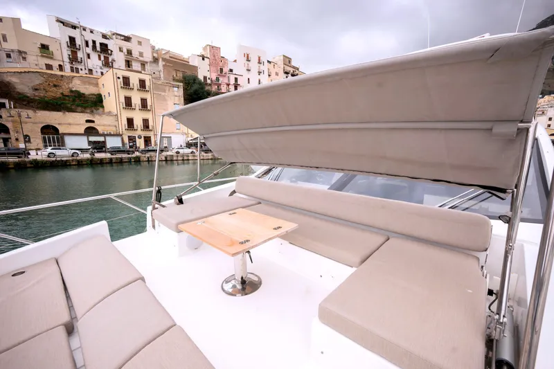 M/y Golden Pearl Yacht Photos Pics 2017 Azimut yacht deck with seating and table, docked near waterfront buildings.