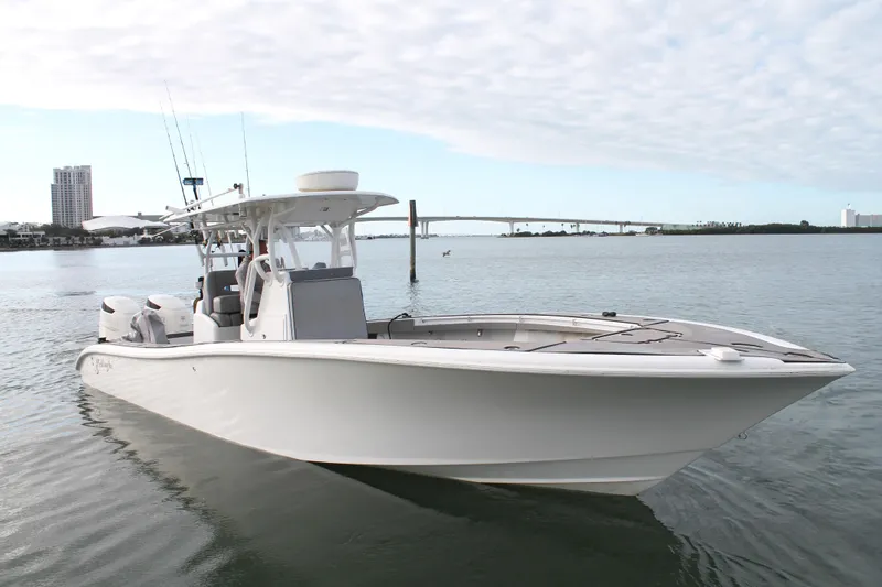  Yacht Photos Pics 2005 Yellowfin 31 Center Console boat on calm water with cityscape background.