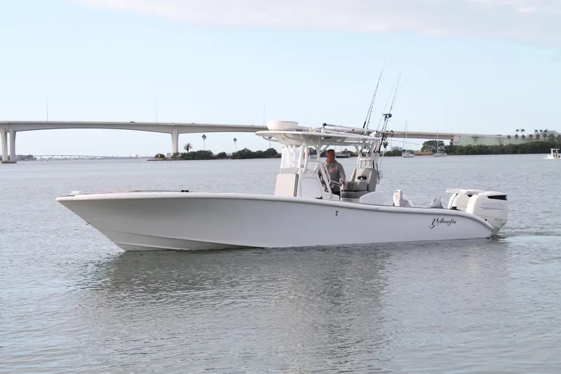  Yacht Photos Pics 2005 Yellowfin 31 Center Console boat cruising on calm waters near a bridge.