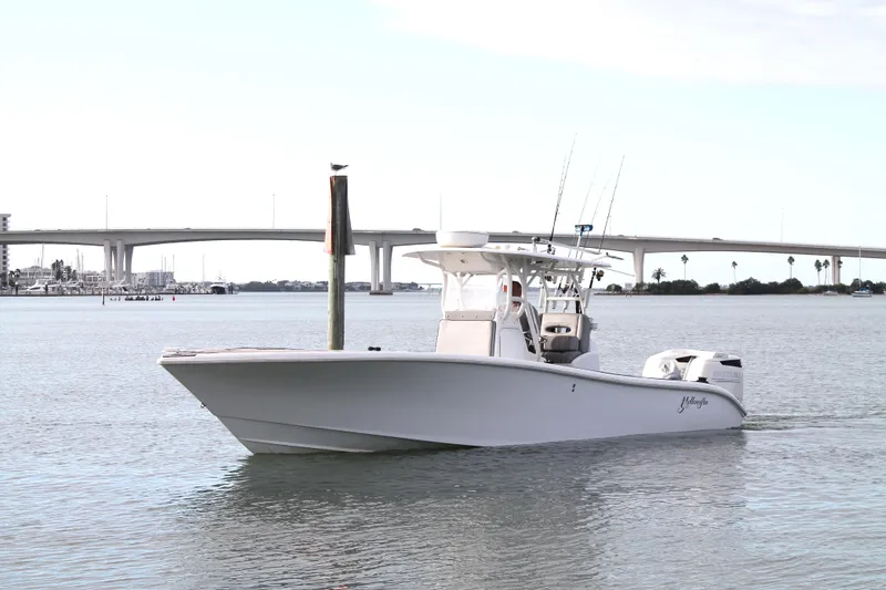  Yacht Photos Pics 2005 Yellowfin 31 Center Console boat on calm water near a bridge.