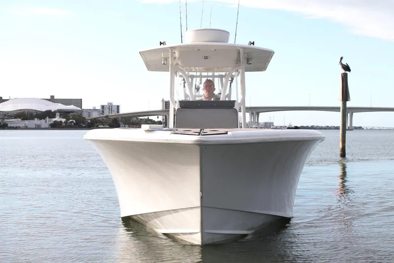  Yacht Photos Pics 2005 Yellowfin 31 Center Console boat on calm water near a bridge.