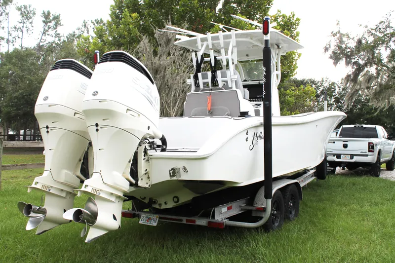  Yacht Photos Pics 2005 Yellowfin 31 Open boat on trailer with dual outboard engines, parked on grass.
