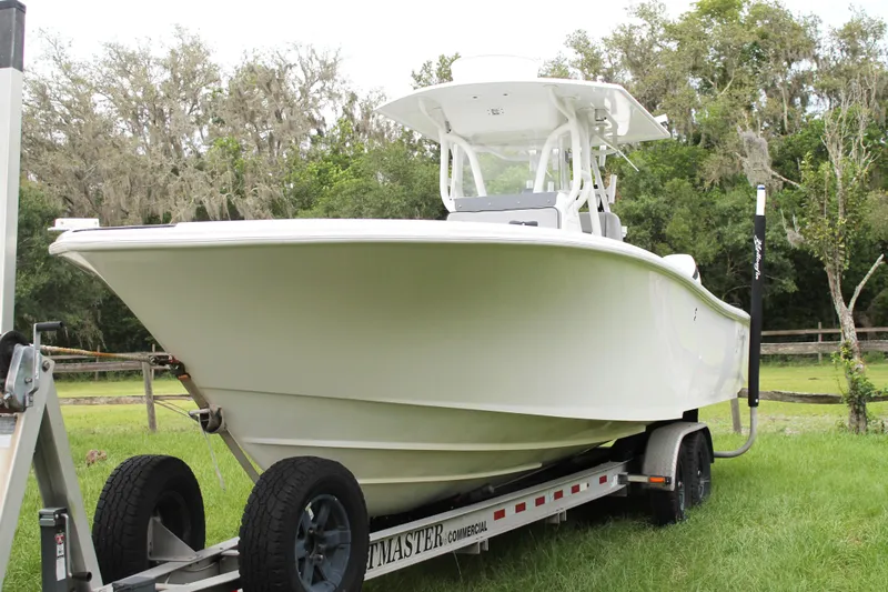  Yacht Photos Pics 2005 Yellowfin 31 Open boat on trailer, parked on grass with trees in background.